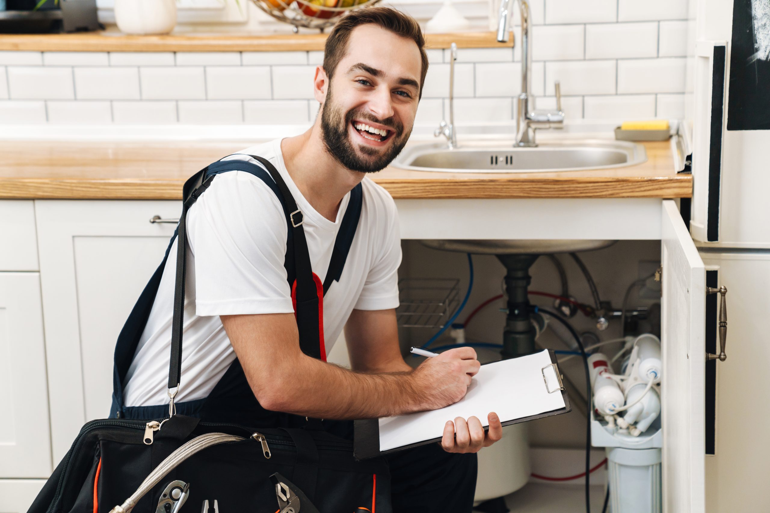 Image of plumber man with equipment and clipboard working in apa